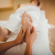 Young woman getting foot massage in therapy room